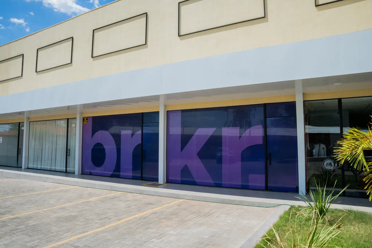 Fachada da Bunker: vitrines com a marca bnkr em roxo, numa galeria de lojas com estacionamento na frente.